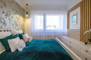 a bedroom with a large blue bed with a window at Hillside Lodge in Budapest