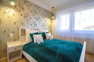 1 dormitorio con 1 cama con colcha verde en Hillside Lodge en Budapest