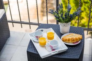 a tray of breakfast food on a table with orange juice at Apartments & Rooms Milcetic D in Malinska