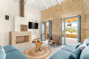 a living room with a blue couch and a fireplace at Patio Villas Complex in Stoupa