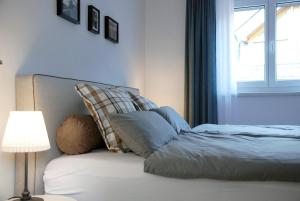 ein Schlafzimmer mit einem Bett mit einer Lampe und einem Fenster in der Unterkunft LUX Ferienwohnung im Weinort Pommern an der Mosel in Pommern