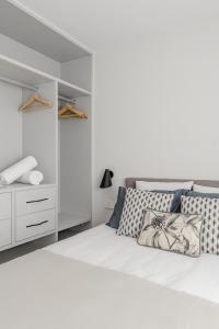 a white bedroom with a large white bed with pillows at Luxury flat Atocha I in Madrid
