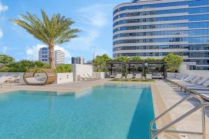 una piscina con sillas y un edificio alto en Downtown Fort Lauderdale 1BR w WD Pool Gym MIA-12, en Fort Lauderdale