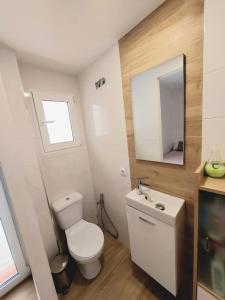 a bathroom with a toilet and a sink and a mirror at CalafellBeach.SeaViews,New in Calafell