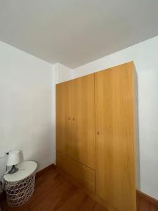 a bathroom with a toilet and a wooden cabinet at Allotjament Sanuy a Tremp in Tremp