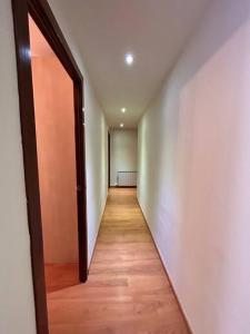 an empty hallway with an open door and a wooden floor at Allotjament Sanuy a Tremp in Tremp