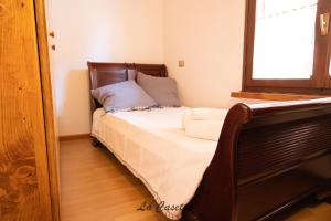 una camera da letto con un letto con lenzuola bianche e una finestra di Comodo appartamento sul lago di lugano a Varese