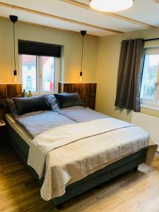 uma cama grande num quarto com 2 janelas em Anderswo Apartments em Langenau