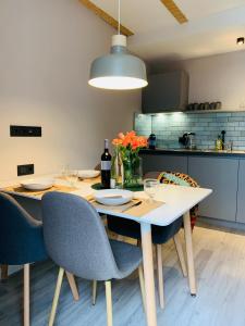 uma cozinha com uma mesa com cadeiras e uma mesa em Anderswo Apartments em Langenau