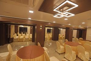 a banquet hall with white chairs and tables in a room at The Zen Park Coimbatore in Coimbatore