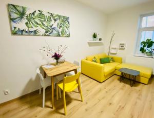 salon z żółtą kanapą i stołem w obiekcie Berta's Apartments w mieście Děčín
