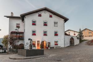 a large white building with red flowers in the windows at Ansitz Zehentner in Laion