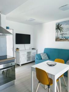 salon z niebieską kanapą i stołem w obiekcie Red Hibiscus Corralejo iRent Fuerteventura w Corralejo