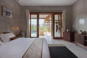 a bedroom with a large bed and a sliding glass door at Kano Canggu in Canggu