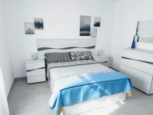 biała sypialnia z łóżkiem i 2 szafkami nocnymi w obiekcie Red Hibiscus Corralejo iRent Fuerteventura w Corralejo +29 zdjęć