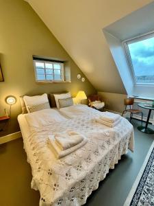 Schlafzimmer mit einem Bett mit weißer Bettwäsche und einem Fenster in der Unterkunft GaestFri Overnatning in Gjern