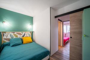 a bedroom with a bed and a room with a door at Perla - Climatisée et proche plage in Canet-en-Roussillon