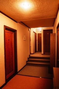 an empty hallway with stairs in a building at 歩絵夢の森 Pension Poem no mori in Hakuba