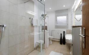 a white bathroom with a shower and a toilet at Am Schmuggerbühl in Bodenmais