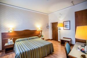 una camera d'albergo con letto e scrivania di Hotel Martelli a Firenze