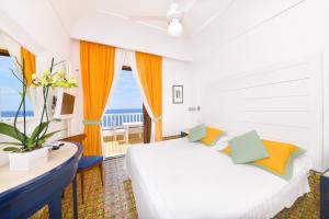 a bedroom with a bed and a large window at Hotel Casa Celestino in Ischia