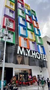 ein großes multifarbenes Gebäude mit einem Kurzzeichen darauf in der Unterkunft M.Y. Hotel in Dumaguete