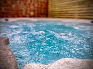 a tub filled with blue water in a room at Brand new luxury 3 Bed Hot Tub House in Blackpool in Blackpool