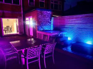 a patio with a table and chairs and purple lights at Brand new luxury 3 Bed Hot Tub House in Blackpool in Blackpool