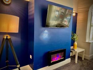 a blue wall with a fireplace in a room at Brand new luxury 3 Bed Hot Tub House in Blackpool in Blackpool