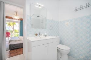 La salle de bains est pourvue d'un lavabo blanc et de toilettes. dans l'établissement Vivenda Aromas do Algarve, à Monte Raposo