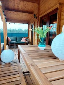 une table en bois avec un vase de fleurs. dans l'établissement ŁAP LAS Wiktorowo, 