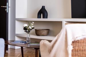 a table with a vase of flowers on it at Unirii Center Apartments by Olala Homes in Bucharest