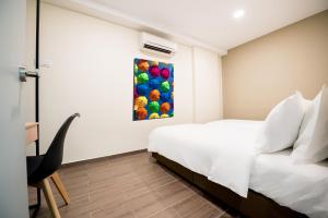 een slaapkamer met een bed en een schilderij aan de muur bij Chill Suites Kuala Lumpur in Kuala Lumpur