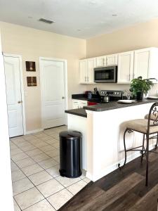 a kitchen with white cabinets and a counter top at Cozy Villa With South Facing Pool in Davenport