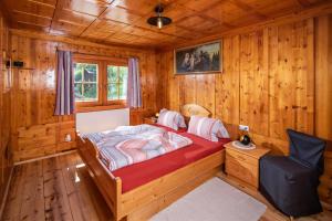 een slaapkamer met een bed in een houten hut bij Haus Oschtna in Sankt Veit in Defereggen