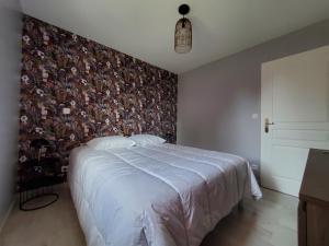 a bedroom with a large bed with a floral wallpaper at Hortensia, Gîte famille et amis in Fontenay-le-Comte