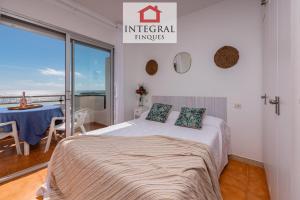 a bedroom with a bed and a balcony with a table at Cala Margarida in Palamós
