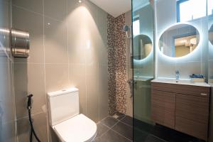 a bathroom with a toilet and a glass shower at Chill Suites Kuala Lumpur in Kuala Lumpur