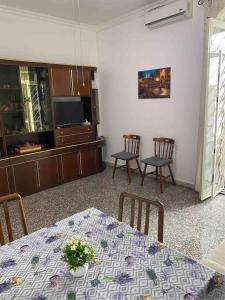 een eetkamer met een tafel en stoelen en een televisie bij Maria luisa house in Rome
