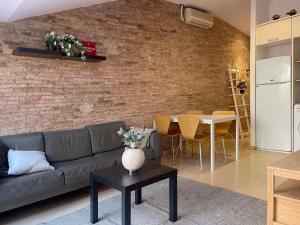 - un salon avec un canapé et un mur en briques dans l'établissement SF Apartamento céntrico con terraza, à Terrassa