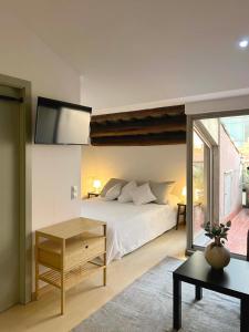 - une chambre avec un lit et une télévision murale dans l'établissement SF Apartamento céntrico con terraza, à Terrassa