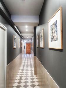 un corridoio con pareti nere e pavimento a scacchi di LARBRENVILLE Gîtes citadins en centre-ville historique a La Charité