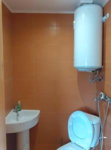 La salle de bains est pourvue de toilettes blanches et d'un lavabo. dans l'établissement Guest house Kashtata, à Shabla