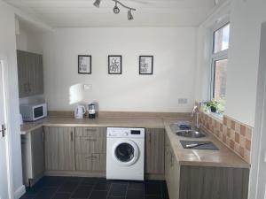 a kitchen with a washing machine and a sink at Wilton - Perfect Home for Contractors Private Large Drive in Newcastle upon Tyne