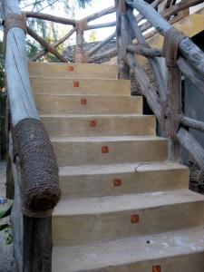 un conjunto de escaleras de madera con pasamanos en Casa Umoja, en Nungwi