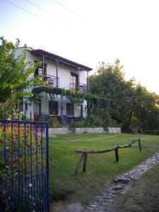 ein Haus mit einem Zaun und einer Schaukel im Hof in der Unterkunft Mirsini Apartments in Kariotes