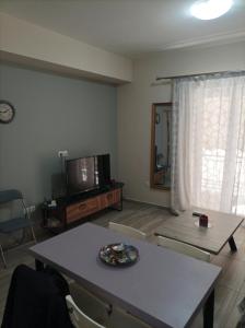 a living room with a table and a tv at Alimos Apartments in Athens