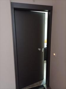 a black door with a mirror in a room at Alimos Apartments in Athens