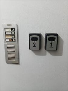 two electrical outlets on a white wall with two numbers at Alimos Apartments in Athens