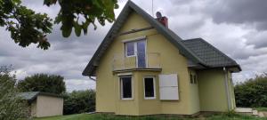 a yellow house with a balcony on top of it at Siedlisko Gródek Dwór 